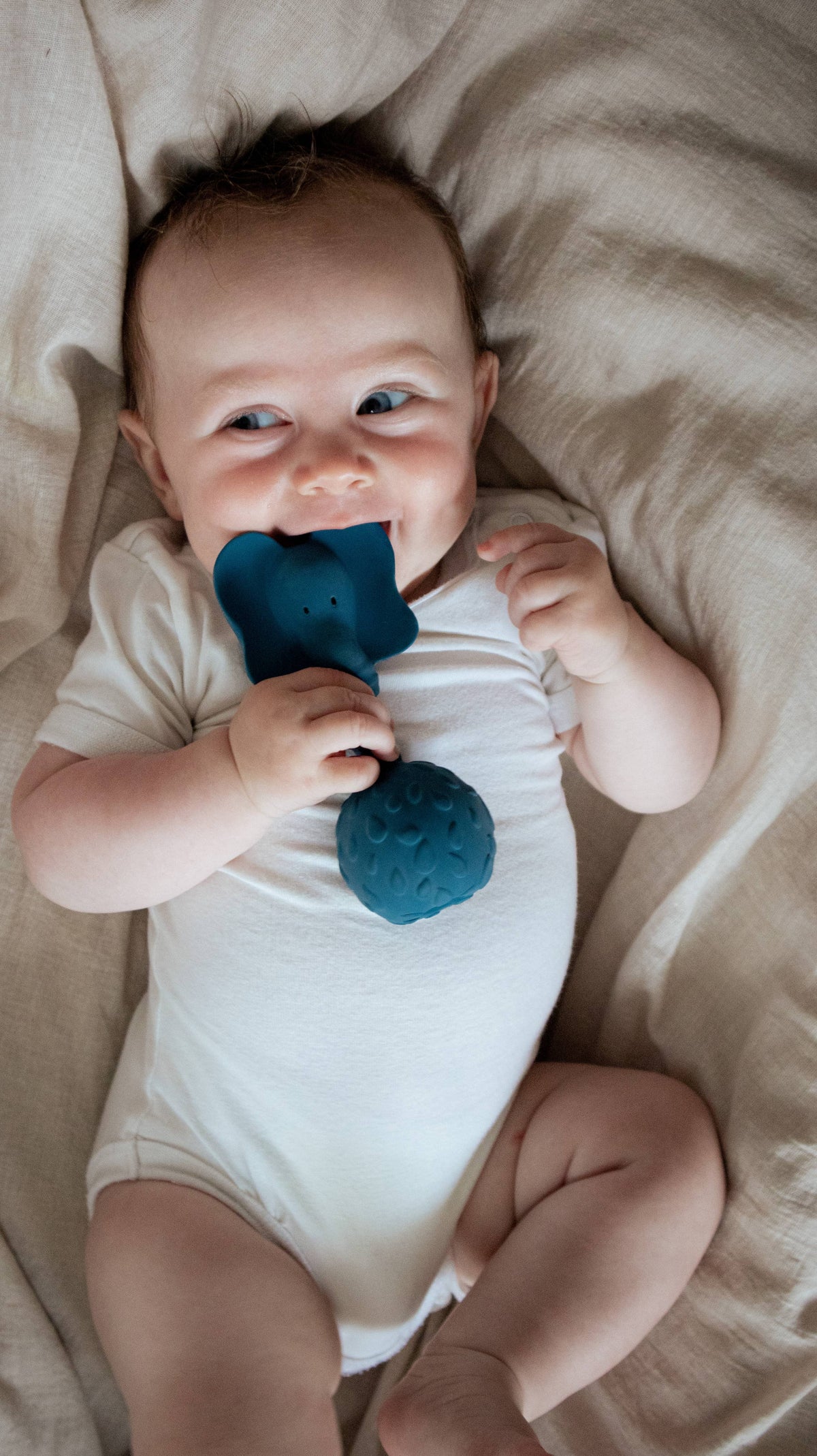 Baby met een blauw olifant rammelaar van Natruba, gemaakt van natuurrubber