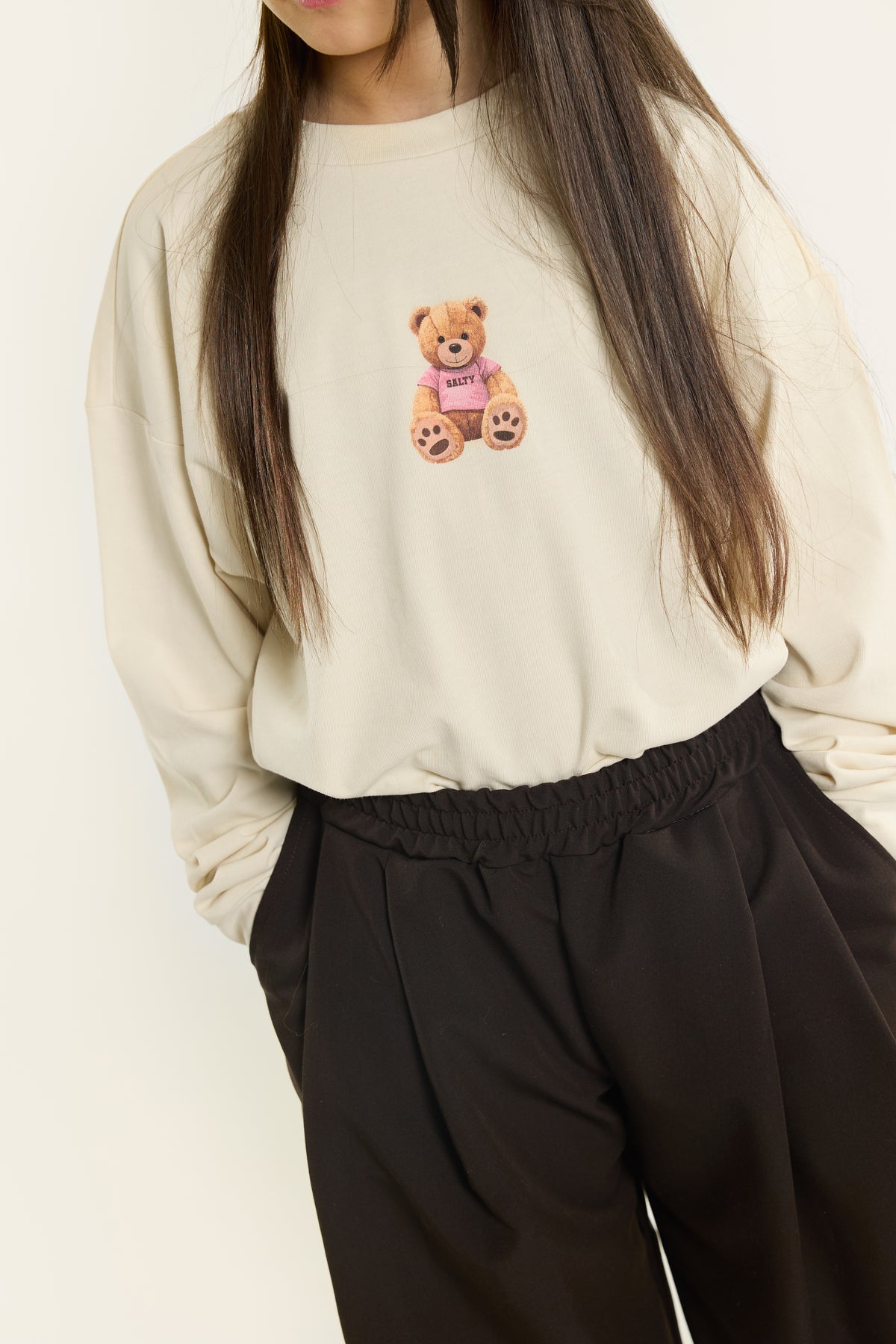 Kind trägt Salty Skater Tee Cozy Teddy Beige Vorderansicht von Salty Stitch