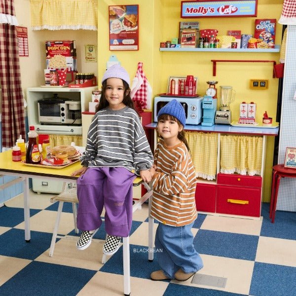 Kinder in gestreiften Black Bean Shirts mit weiten Hosen und Mützen