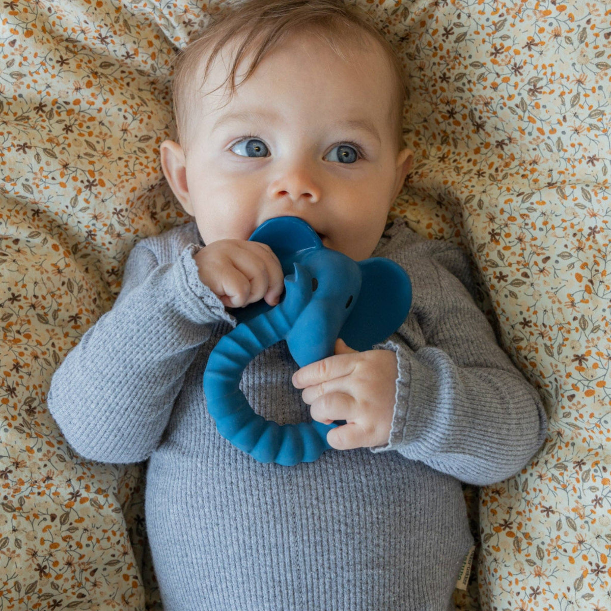 Baby with a blue elephant teether by Natruba, made from natural rubber