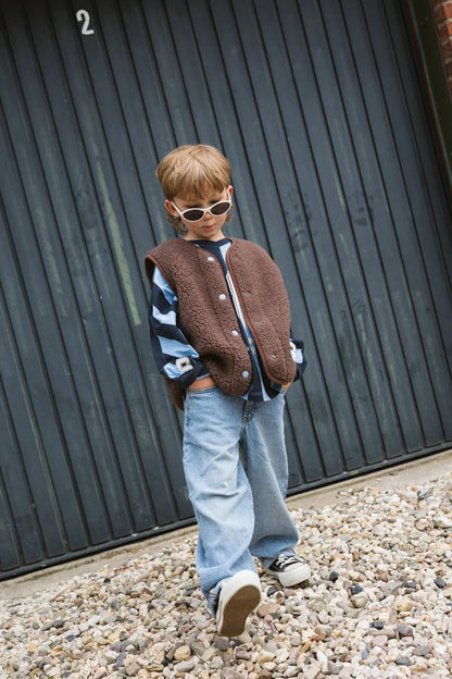 Kind draagt braune Salty x Alwero Bodywarmer Cozy Club van Salty Stitch