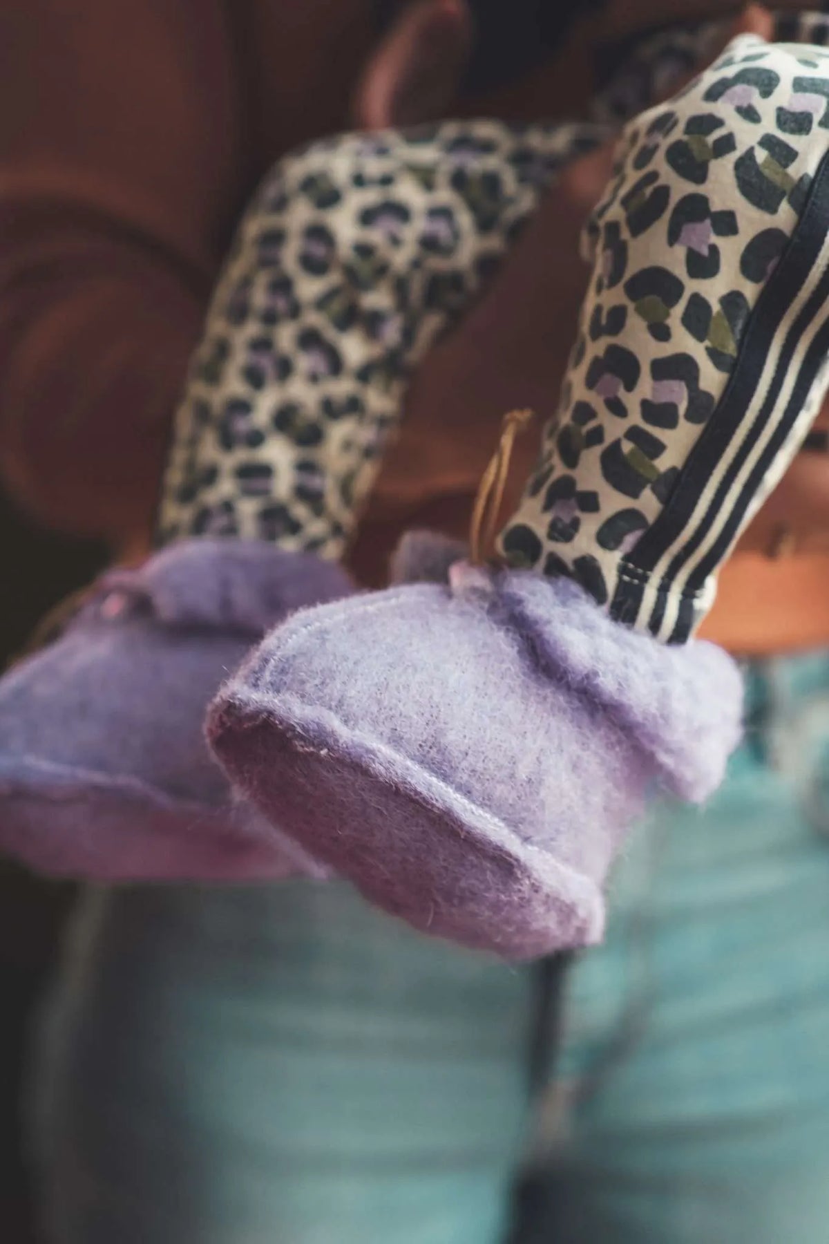 Baby mit lila Wollschuhen von We Are Wovens