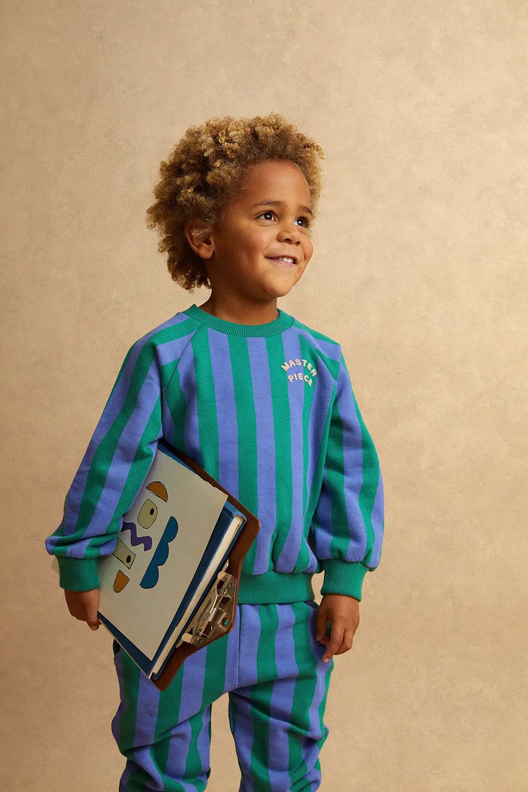 Kind trägt grün blau gestreiftes Sweatshirt von Sproet & Sprout