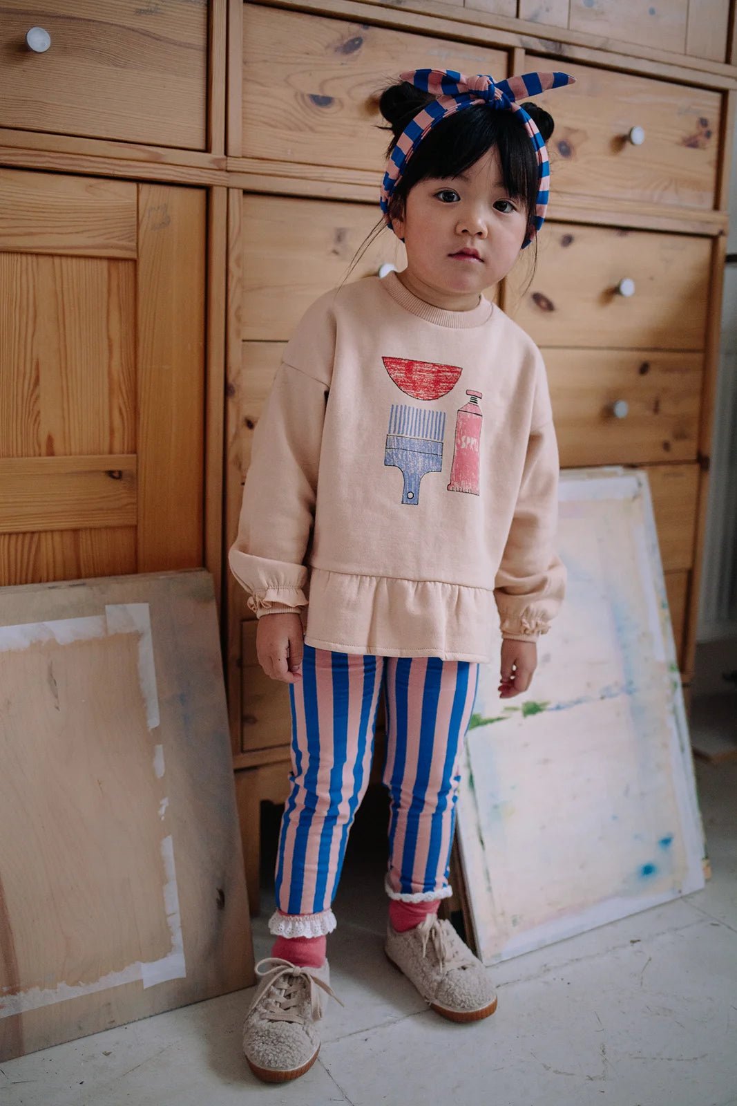 Kind trägt blau pink gestreifte Leggings von Sproet & Sprout