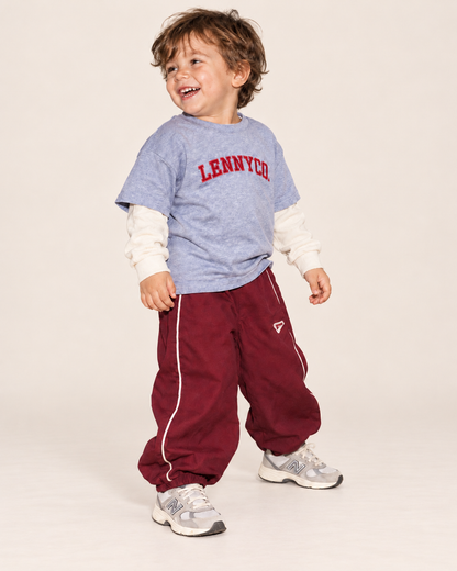 Kind trägt weinrote Berry Track Pants