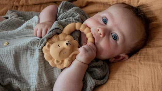 Baby with a yellow lion teether by Natruba, made from natural rubber
