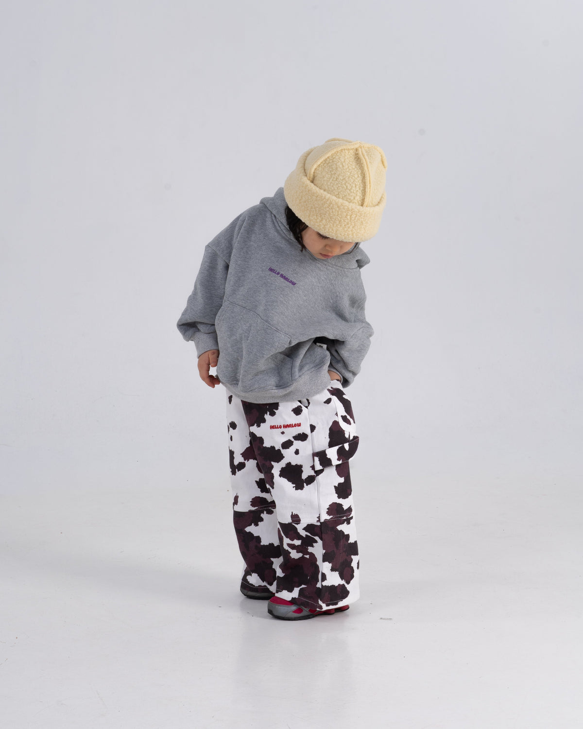 Kind trägt Cow Pants mit Kuhmuster von Hello Harlow
