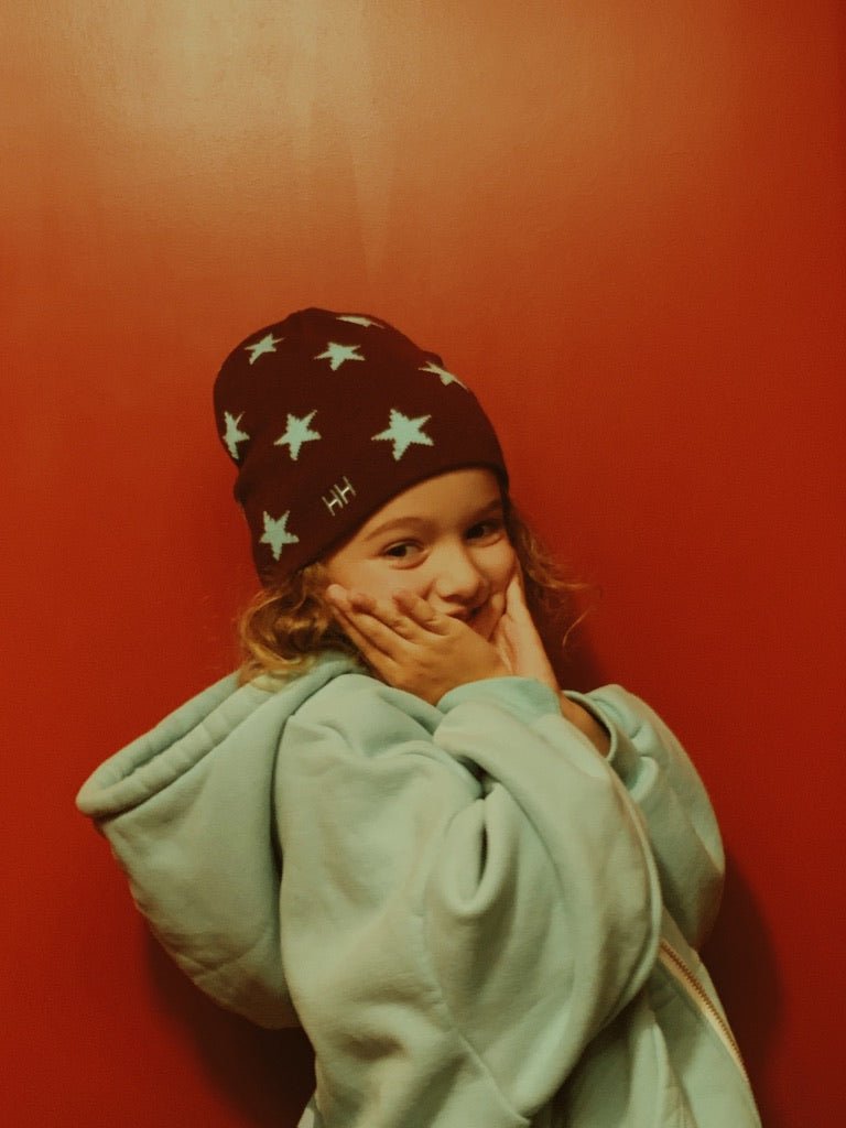 Child wearing burgundy Star Beanie with light blue stars by Hello Harlow