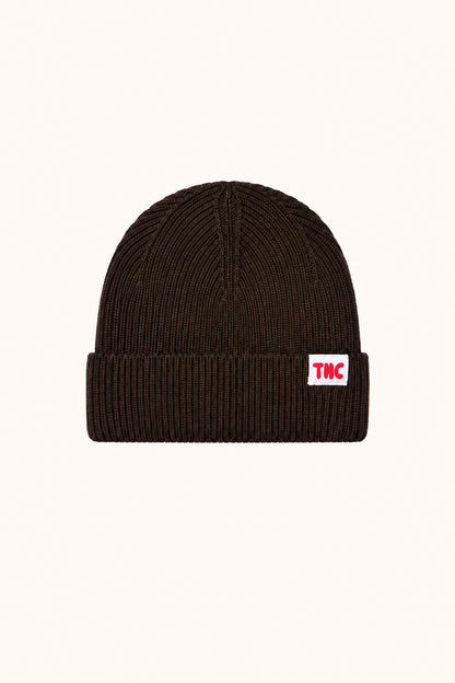 The New Chapter Jip Beanie Brown Stone auf warmem beigefarbenem Hintergrund