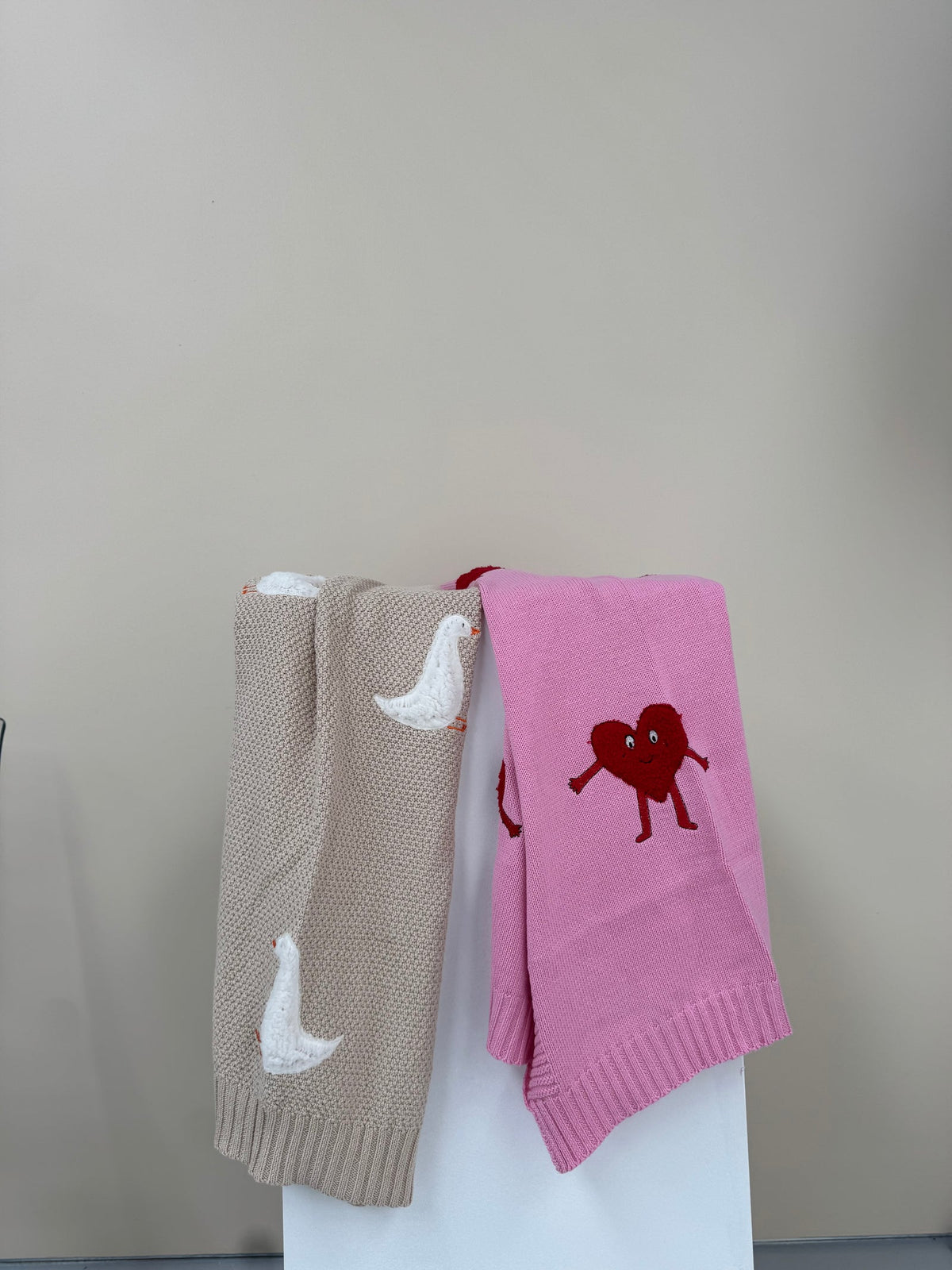 Roze Heartman en beige Gordy Goose babydekens van Lennyco naast elkaar