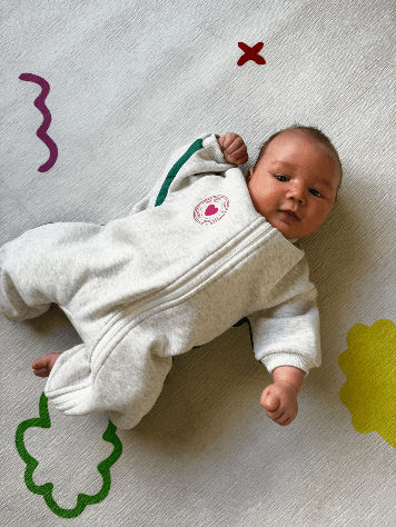 Baby draagt grijs fleecepakje van Lennyco met groene strepen